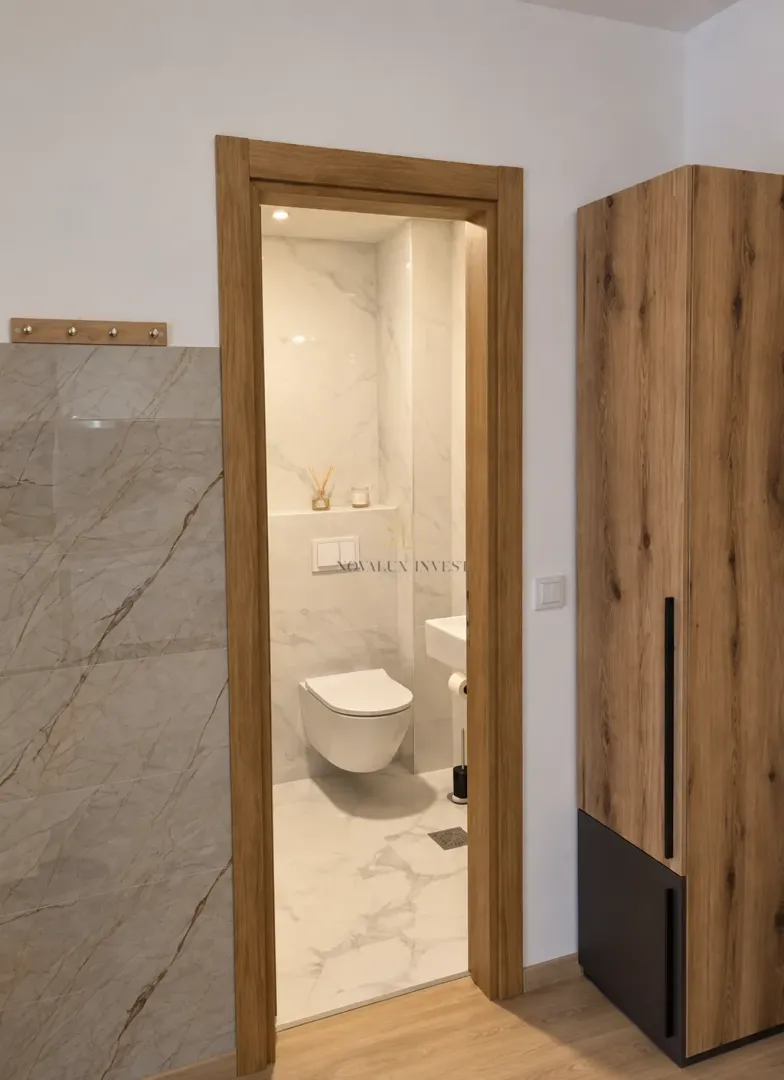 View of a modernly equipped bathroom through the open door.