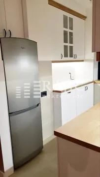 Modern kitchen with white cabinetry and a large refrigerator. - image 3