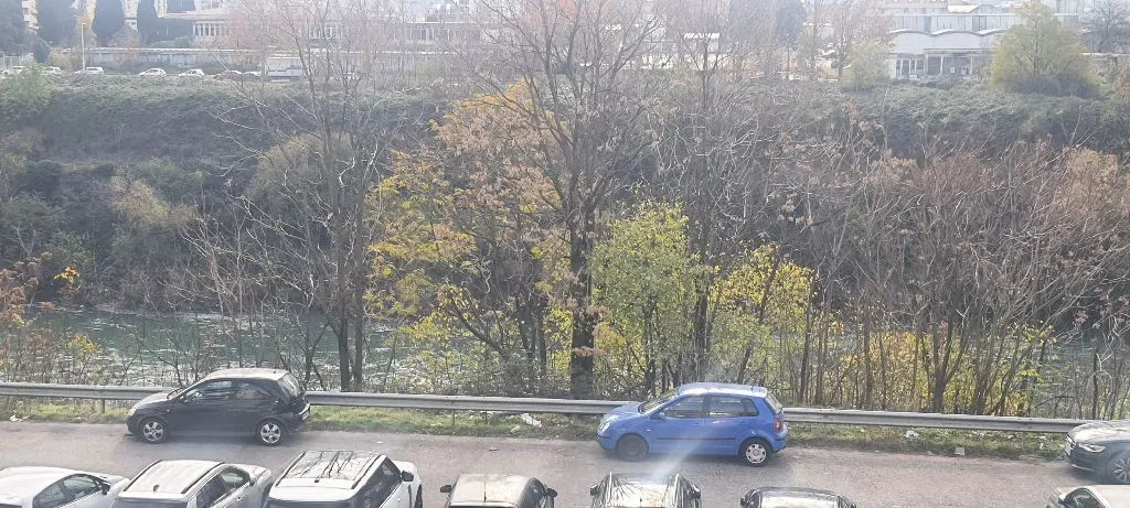 Pogled iz objekta na rijeku i drveće.