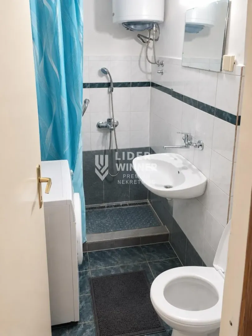 Manje kupatilo sa tuš kabinom, umivaonikom i wc šoljom.