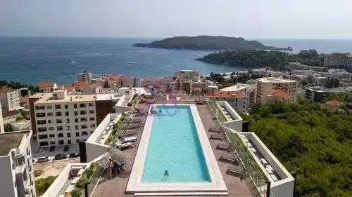Pogled iz vazduha na krovni bazen i okolne zgrade sa pogledom na more.