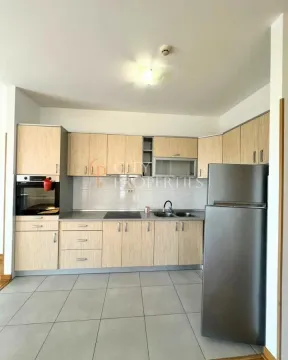 Kuhinja sa drvenim elementima, ugradnom rernom i frižiderom. - image 4