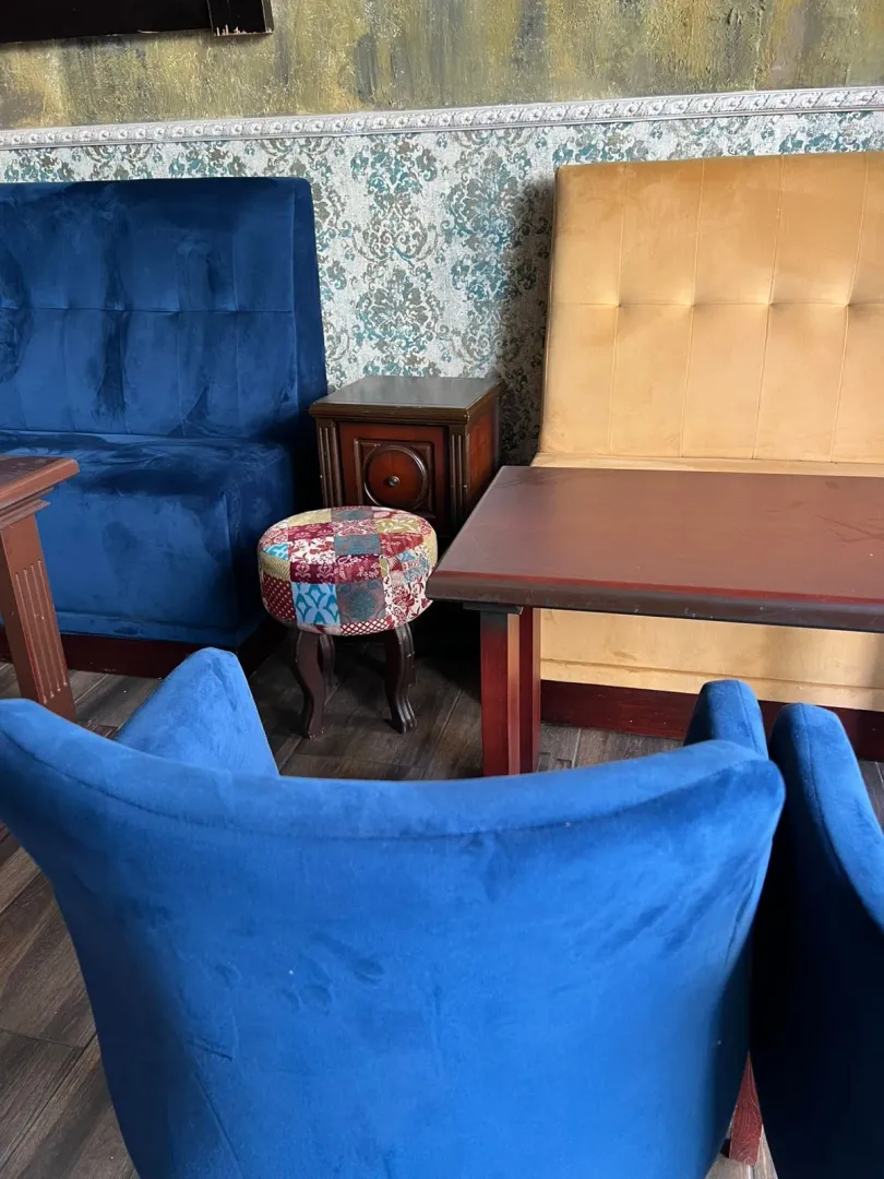 Living room with upholstered armchairs, sofas and a wooden coffee table.