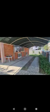 A yard with a covered parking space in front of the house. - image 26