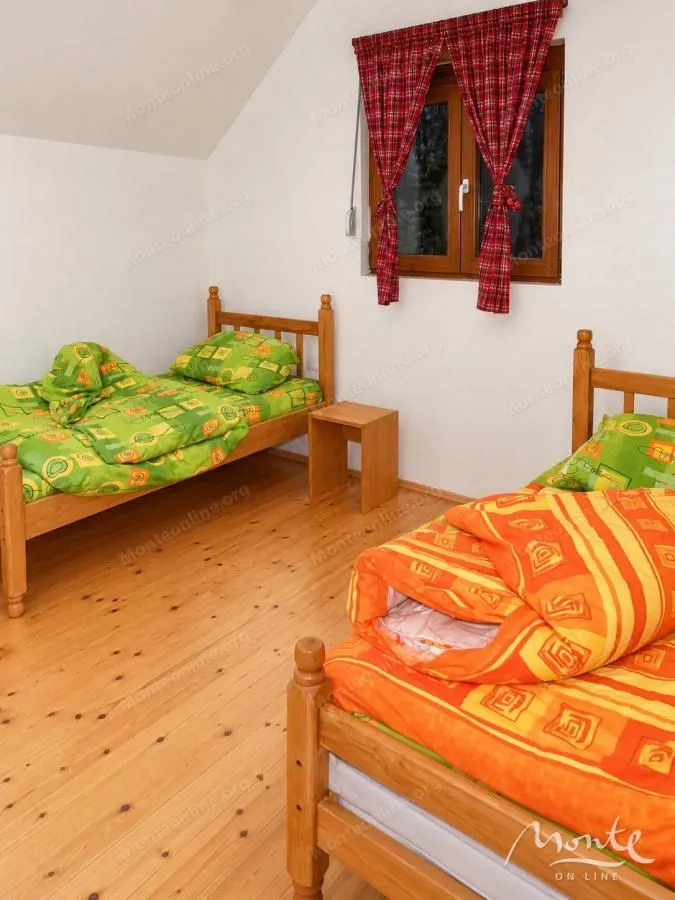 Bedroom with two wooden beds and a window.