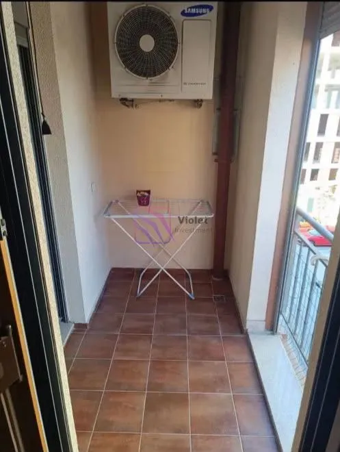 Manji natkriveni balkon sa keramičkim pločicama i spoljnom jedinicom klima uređaja.