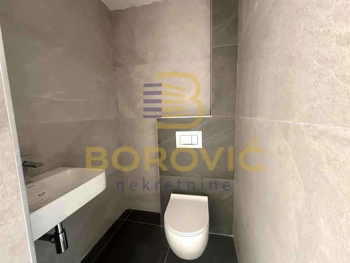 Moderno kupatilo sa umivaonikom i ugradnom wc šoljom.