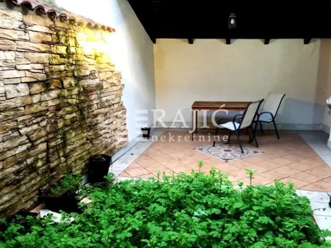 Natkrivena terasa sa kamenim zidom i zelenilom. - image 15