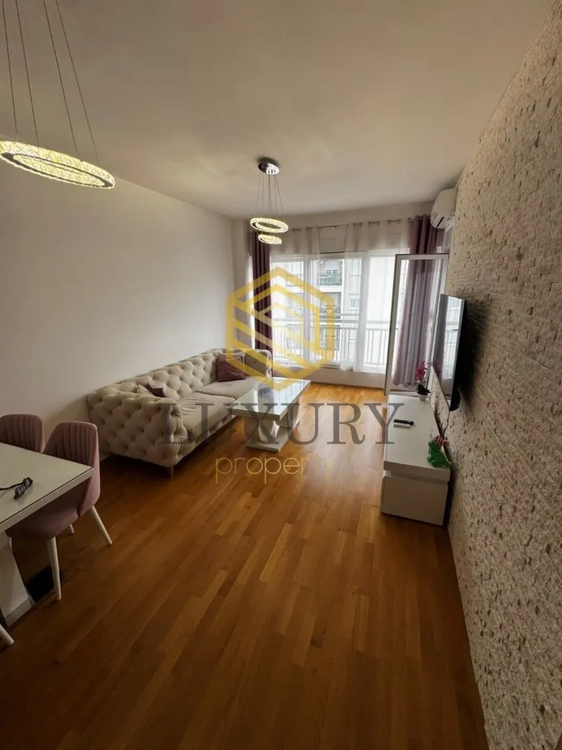 Living room with sofa, dining table, and decorative stone wall.
