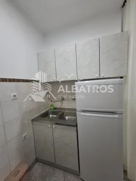 Small kitchen with a sink, cabinetry, and a refrigerator. - image 8