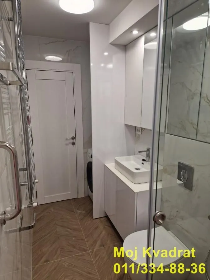 Savremeno opremljeno kupatilo sa umivaonikom, WC šoljom i tuš kabinom.