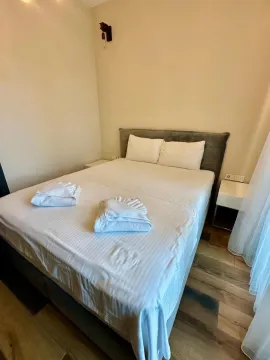 Tidy bedroom with a double bed and folded towels. - image 9