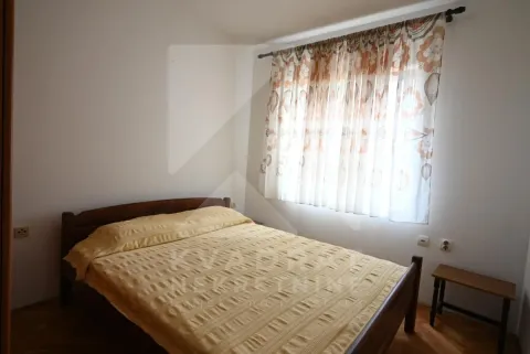 Furnished bedroom with a double bed and a window with curtains. - image 11