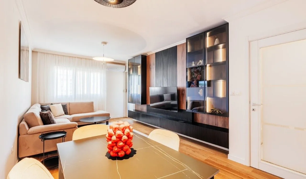 Living room with a sofa, dining table, and modern wall-mounted furniture.