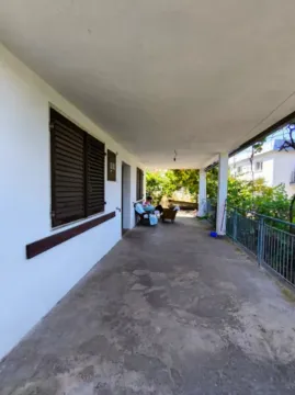 Covered terrace with a view of the yard and greenery. - image 6