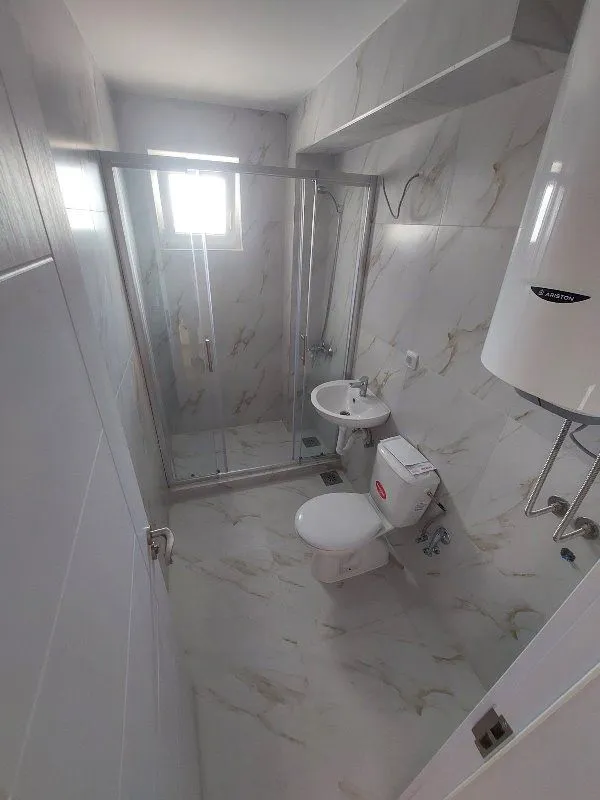 Kupatilo opremljeno tuš kabinom, umivaonikom, WC šoljom i bojlerom.