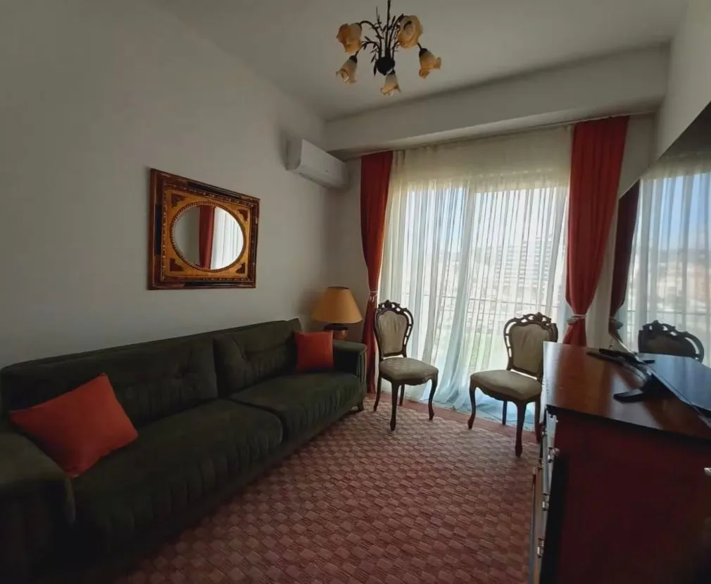 Living room with sofa, small table and access to the terrace.
