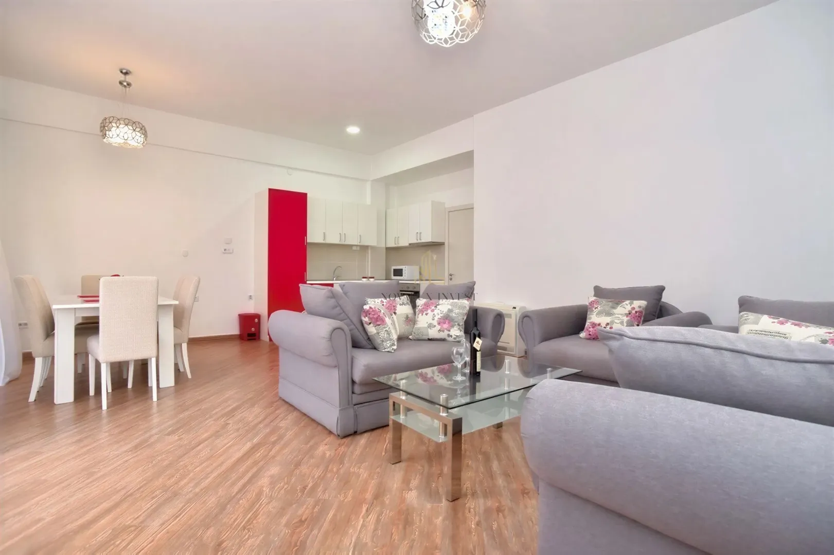 Spacious living room with seating area, dining space and kitchen in the background.