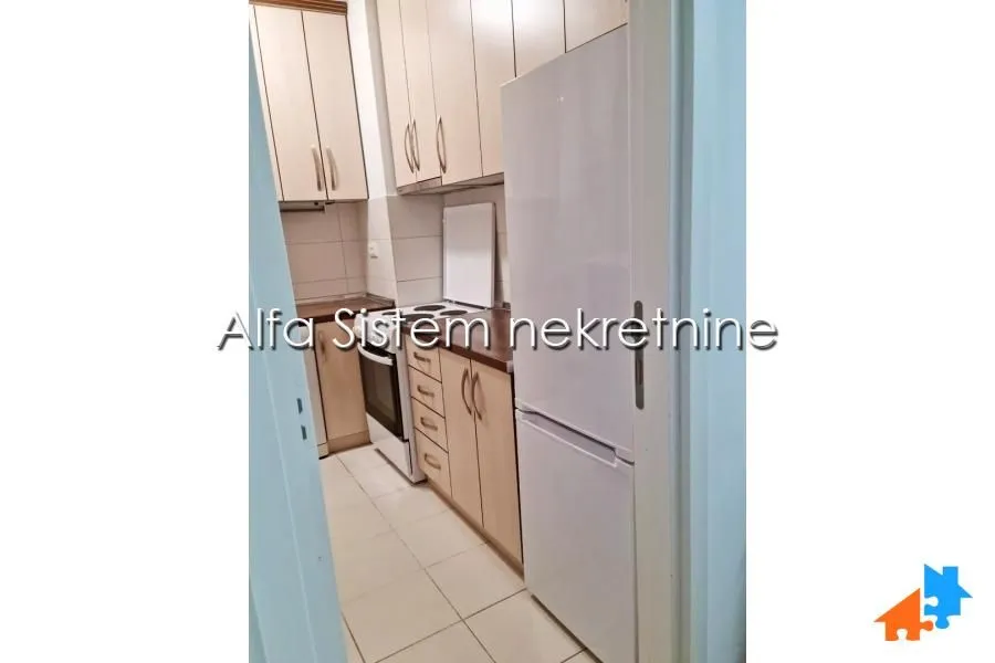 Smaller kitchen with light-colored cabinets and a white refrigerator.