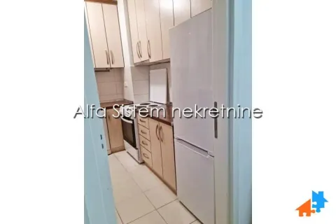 Smaller kitchen with light-colored cabinets and a white refrigerator. - image 13