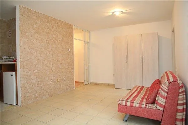 Living room with a sofa, wardrobe, and decorative stone wall.