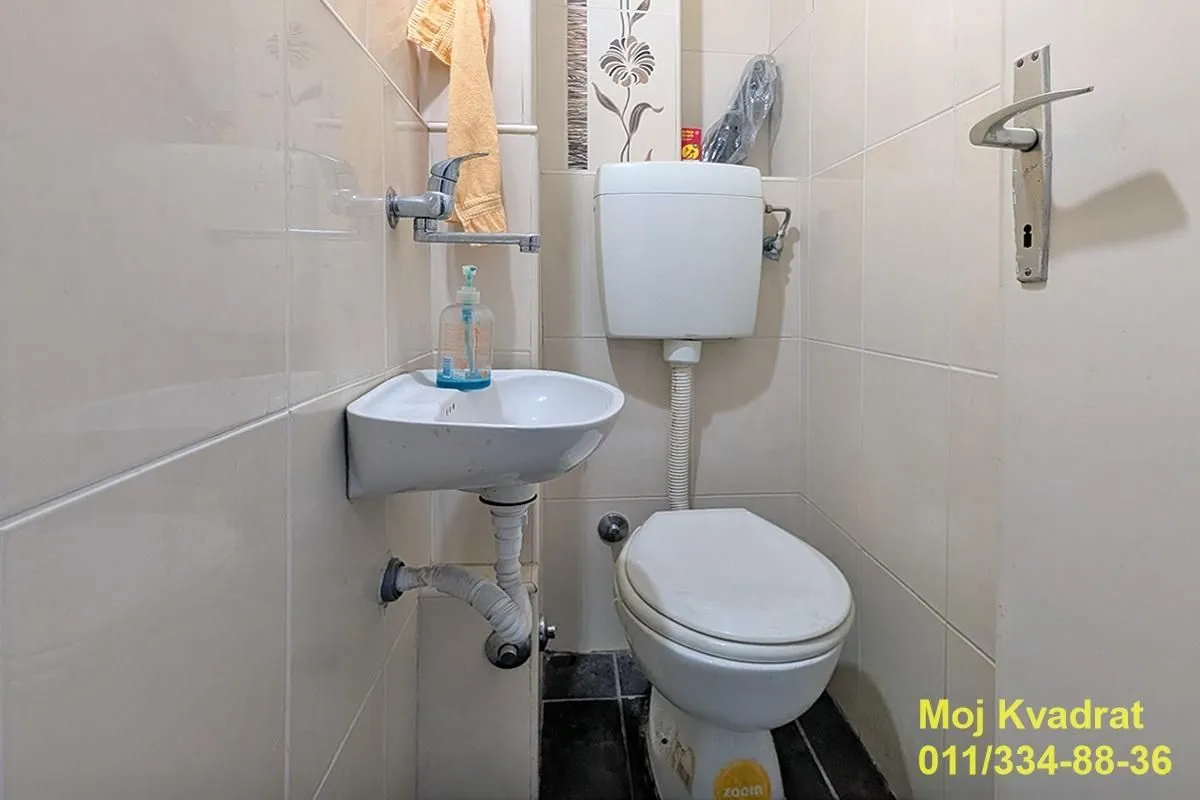 Manje kupatilo sa WC šoljom i umivaonikom.
