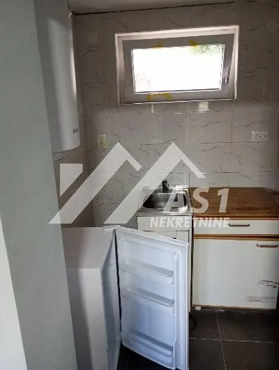 Small kitchen with a sink, refrigerator, and cabinetry.