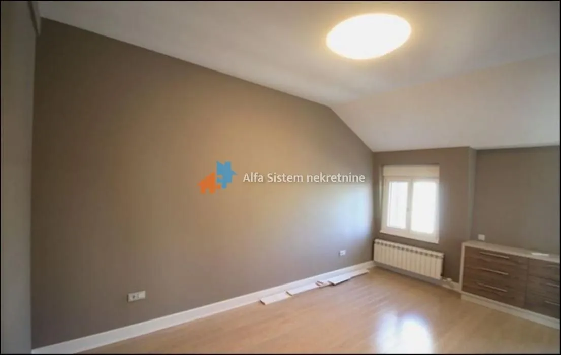 Empty room with parquet flooring and a sloped ceiling.