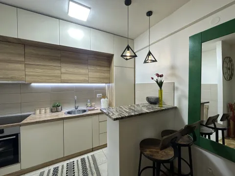 Moderna kuhinja sa drvenim elementima i šankom sa stolicama. - image 3