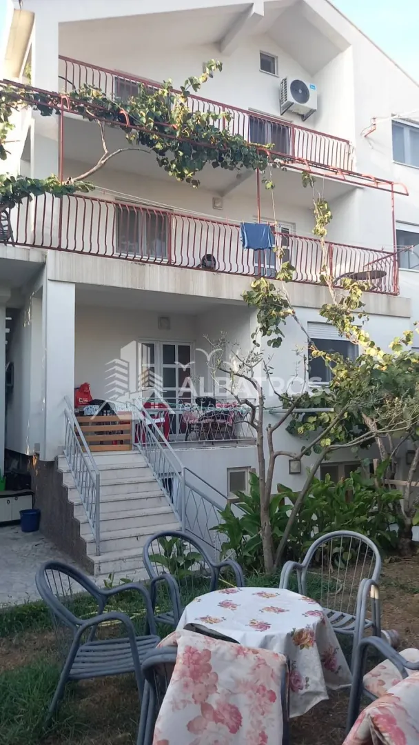 View of the courtyard and house facade with terraces and garden furniture.