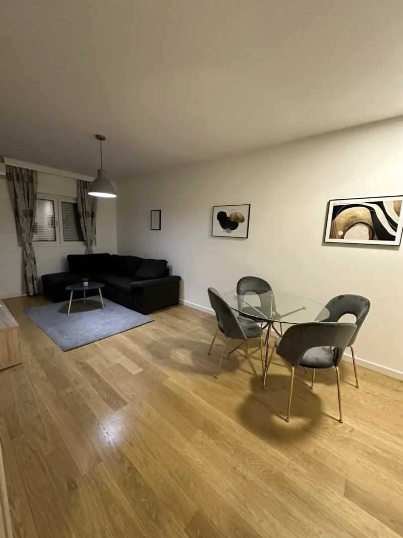 Living room with a corner sofa and a dining table.