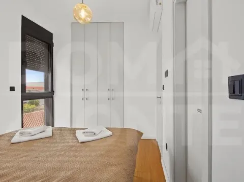 Small bedroom with a double bed, built-in wardrobe, and a window. - image 7