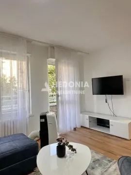 Dnevna soba sa TV-om, niskom komodom, stočićem i izlazom na terasu. - image 5