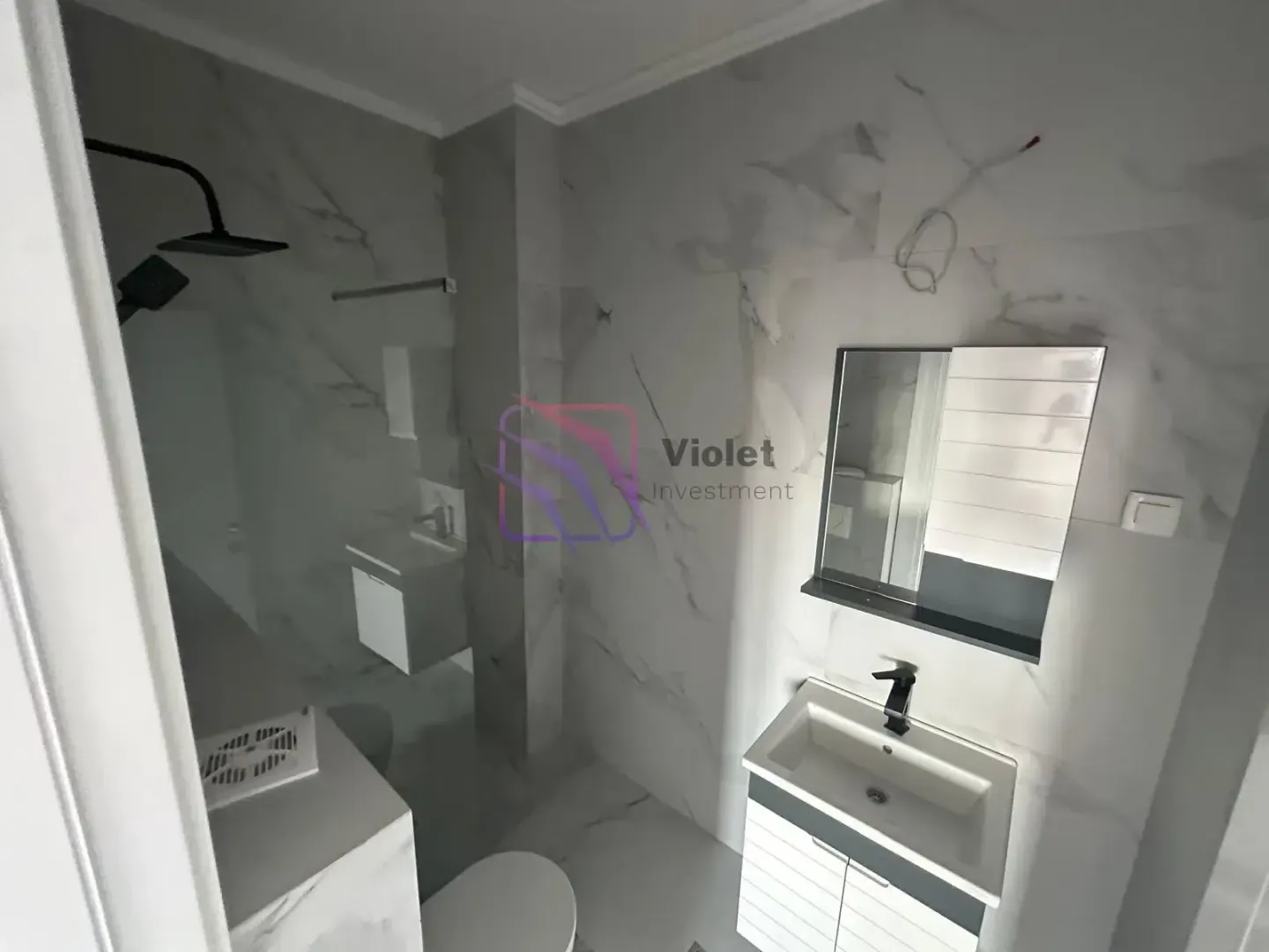 Modernly equipped bathroom with a walk-in shower and a vanity unit.