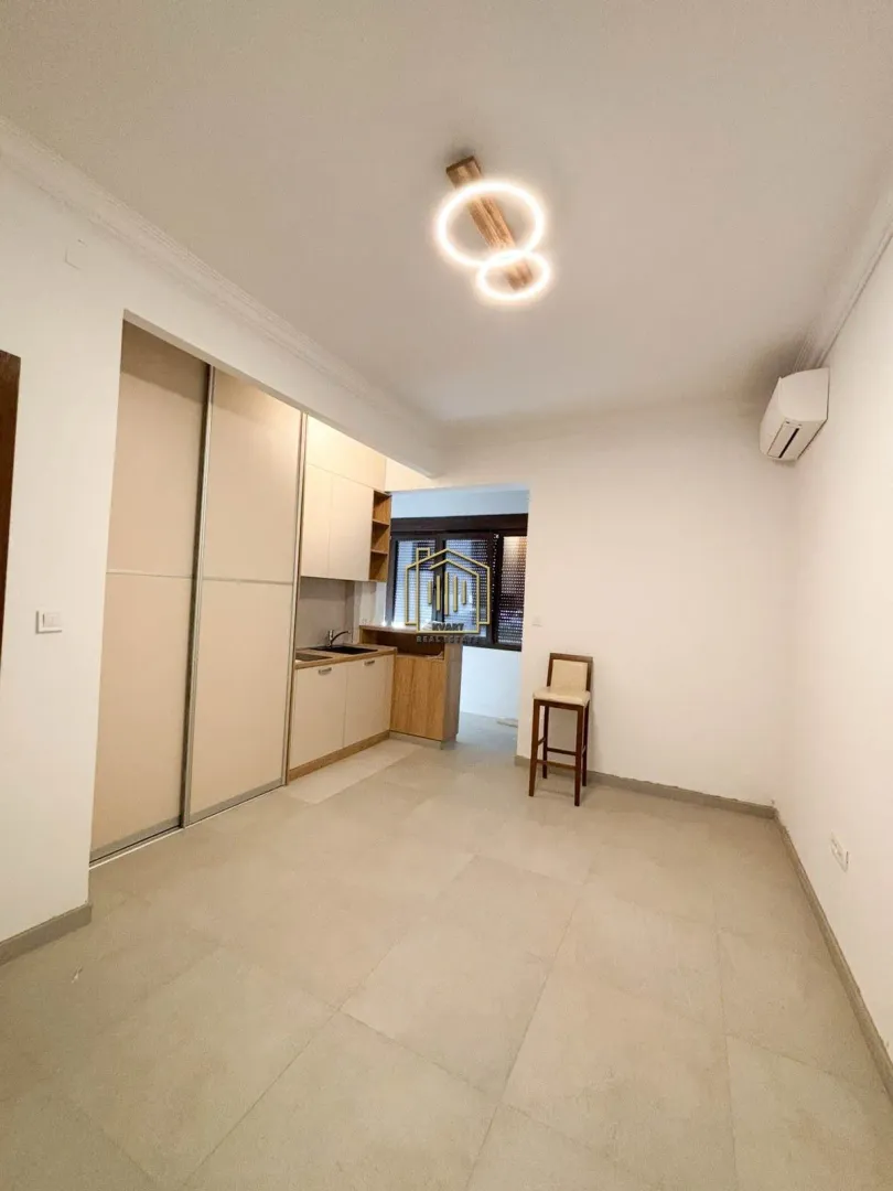 Small kitchen with built-in units and a wardrobe within the room.