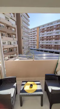 Namješten balkon sa garniturom za sjedenje i pogledom na okolne zgrade. - image 2