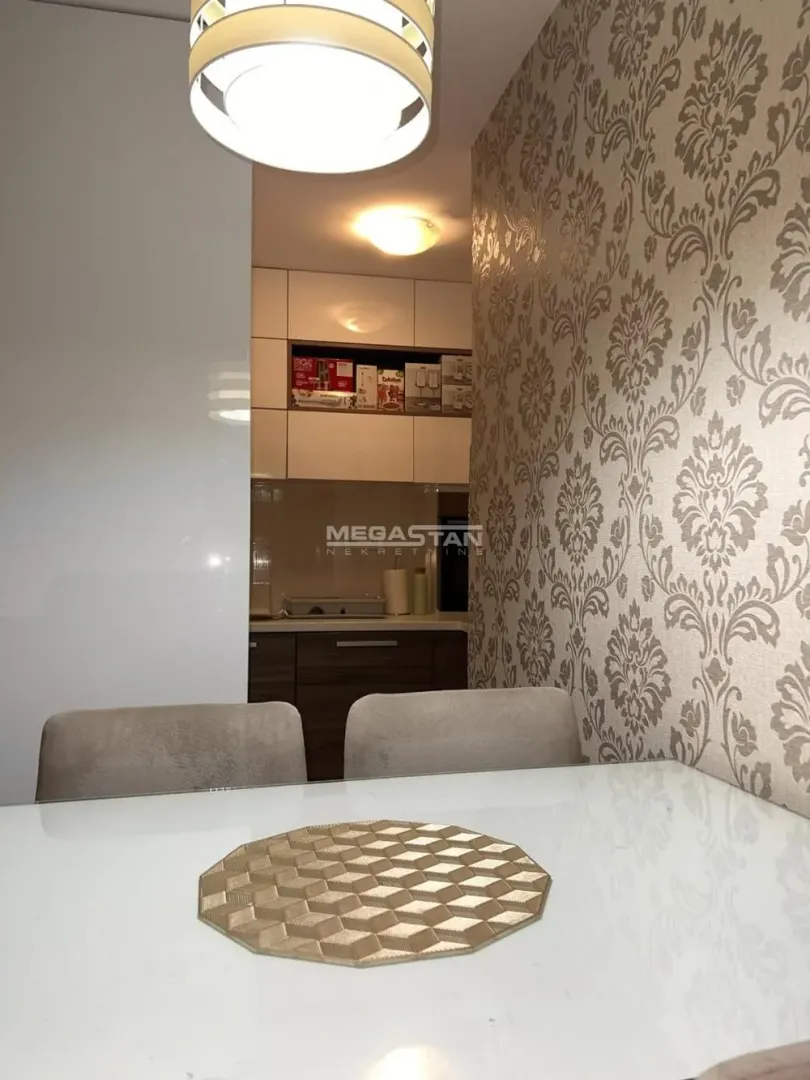 Dining table in the foreground with a view of the kitchen in the background.