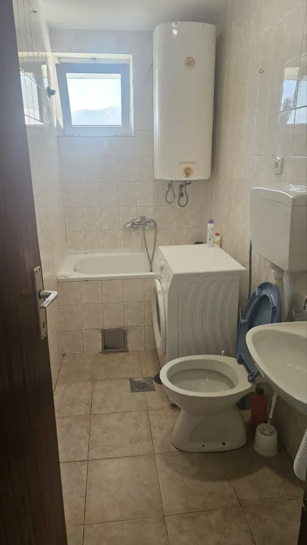 Manje kupatilo sa kadom, vc šoljom, umivaonikom i veš mašinom.
