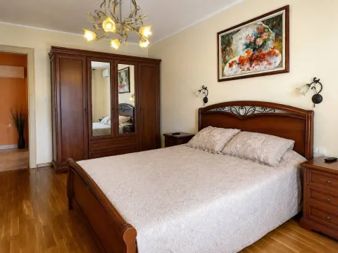 Furnished bedroom with a double bed, wooden wardrobe, and parquet flooring. - image 7