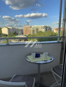 Manji balkon sa stolom i dve stolice i pogledom na grad. - image 10