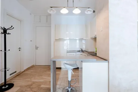 Modern white kitchen with a breakfast bar and a bar stool. - image 3