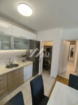 Smaller kitchen with white and wooden cabinets and a dining table. - image 4
