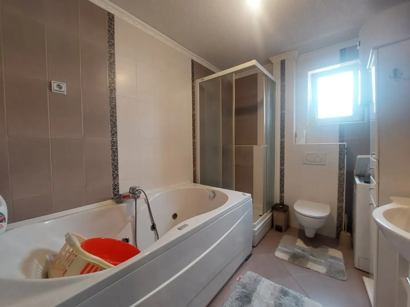 Potpuno opremljeno kupatilo sa kadom, tuš kabinom i sanitarijama.