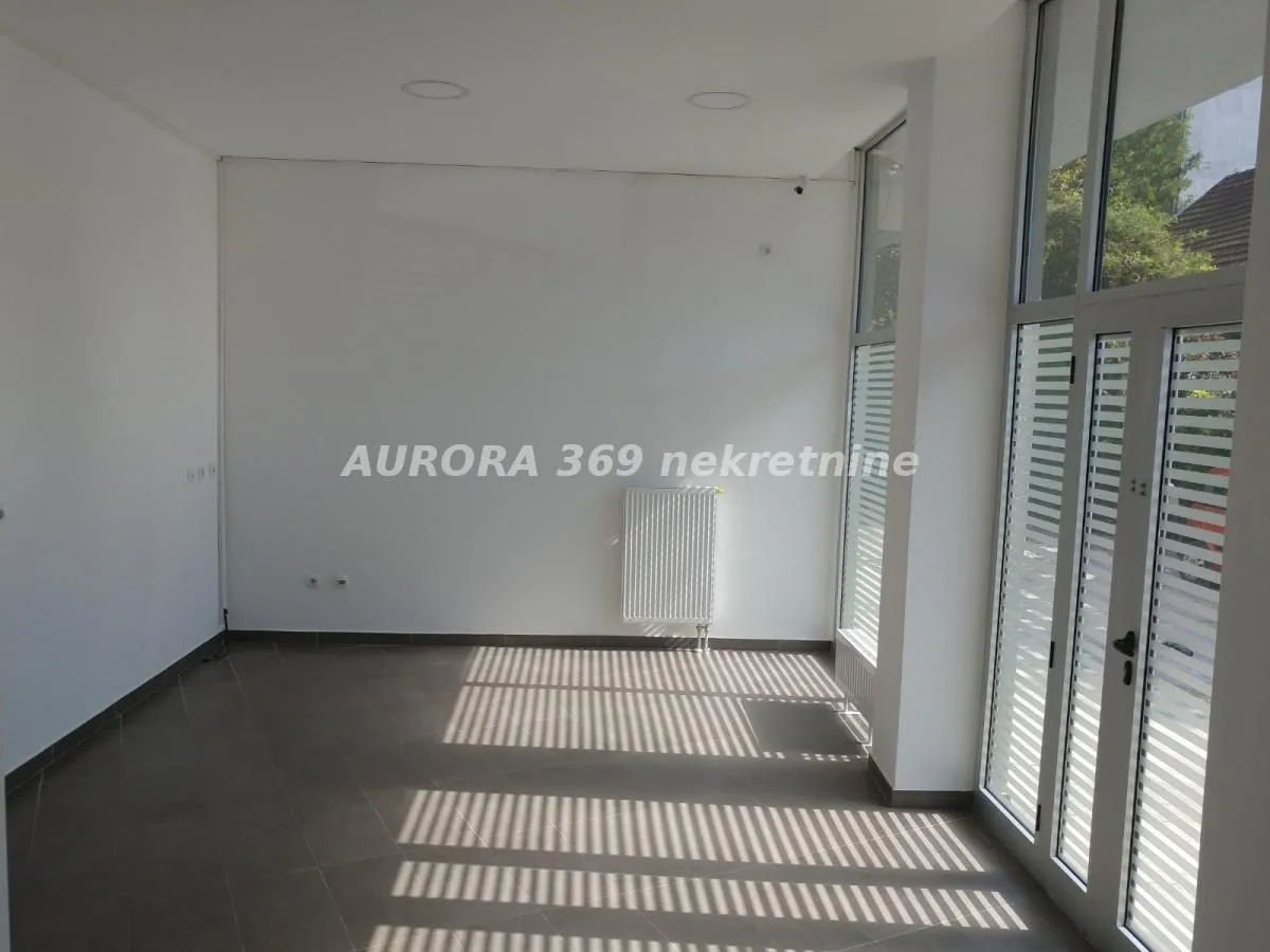 Empty bright room with large windows and tiled floor.