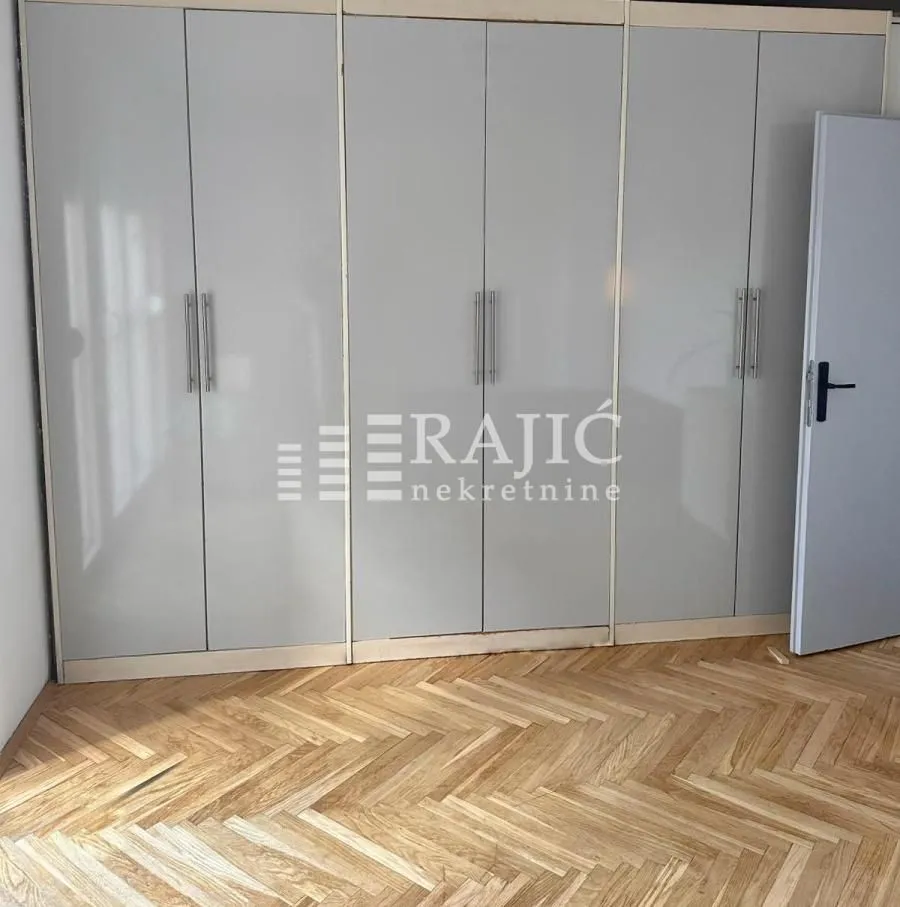 Bedroom with a large built-in wardrobe and parquet flooring.