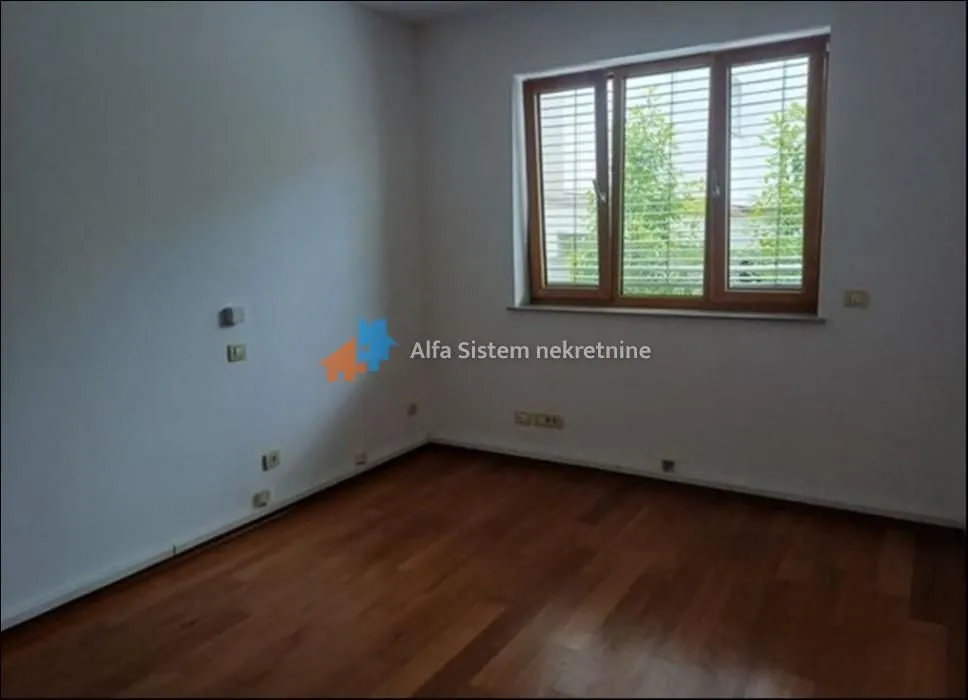 Empty room with wooden flooring and a window.
