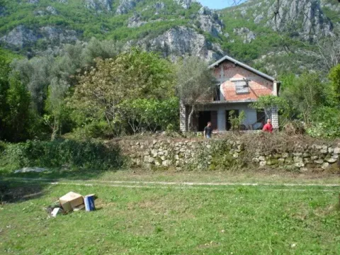 Nedovršena kuća okružena zelenilom i drvećem u podnožju brda. - image 8