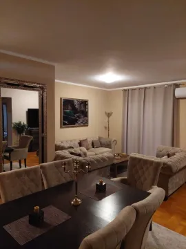Spacious living room with a sofa set and dining table. - image 9