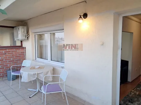 Covered terrace with a table, chairs, and an air conditioning unit. - image 9