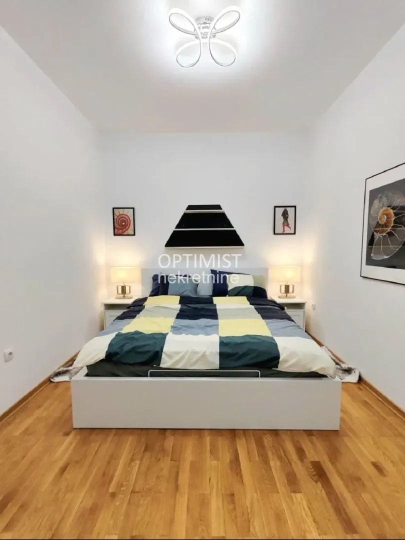 Bedroom with a double bed, nightstands, and wooden flooring.